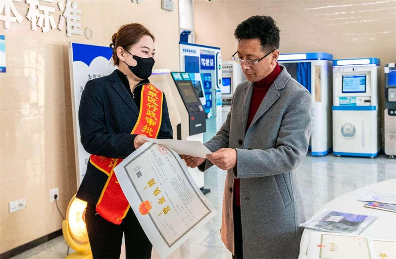 Un travailleur indépendant reçoit une licence commerciale dans un centre de services gouvernemental du district de Yuquan, à Hohhot, capitale de la région autonome de Mongolie intérieure (nord de la Chine), le 7 mars 2024. (Ding Genhou / Pic.people.com.cn)